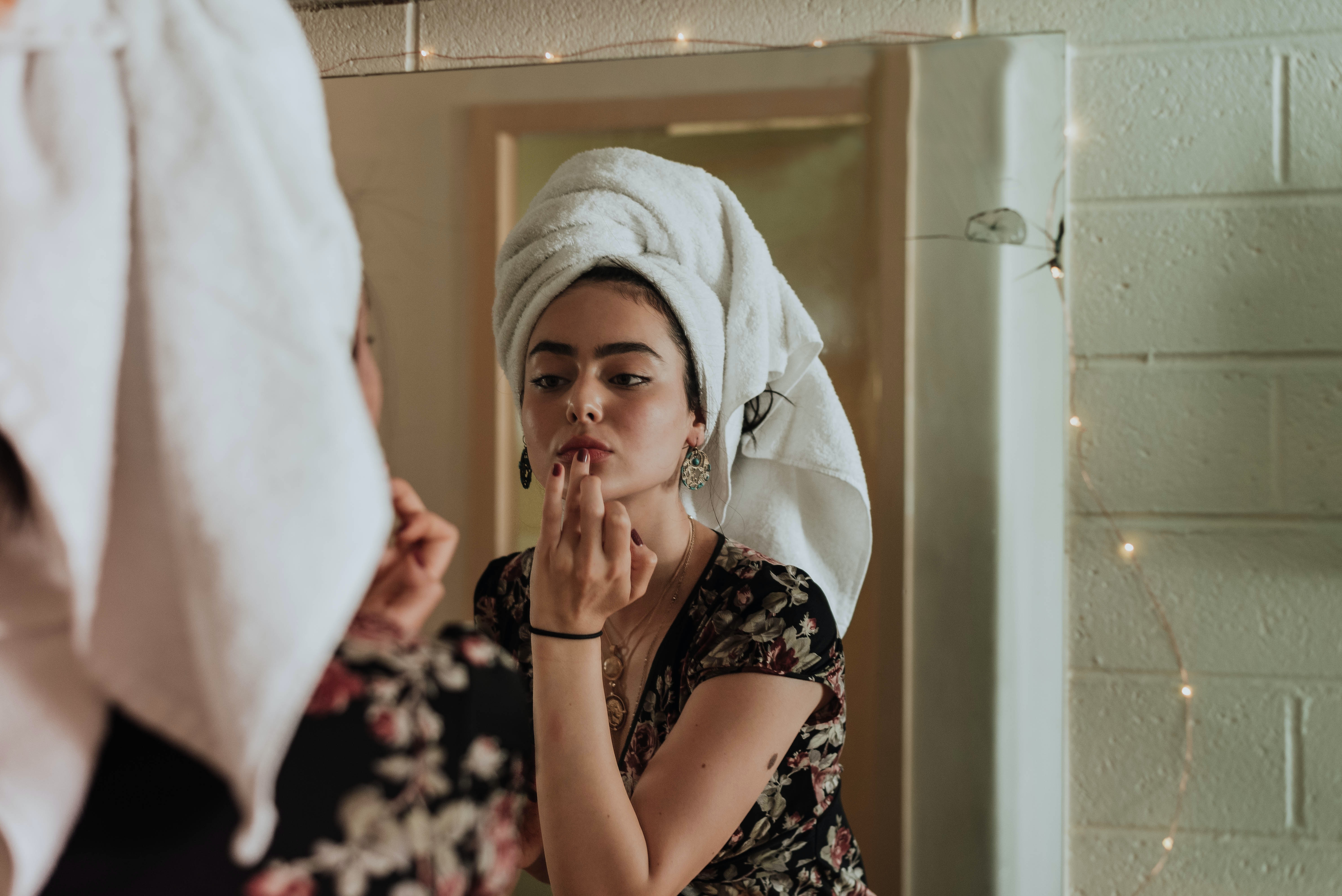 Woman with a towel on her head looking in the mirror in a SPA salon
